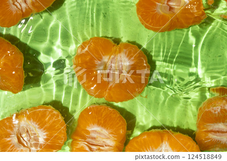 Peeled fresh mandarin halves in water, splash water, top view 124518849