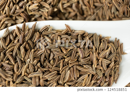 Whole cumin seeds Carum carvi L. in a spoon close-up Whole cumin seeds Carum carvi L. in a spoon close-up 124518851