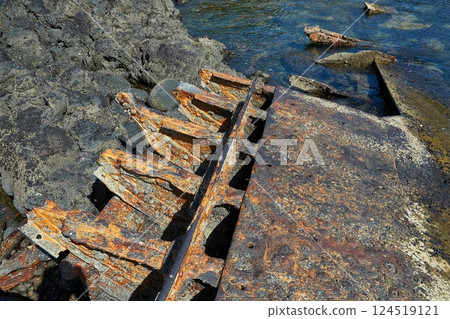 Rusty metal shipwreck rusting away on the shore Rusty metal shipwreck rusting away on the shore 124519121