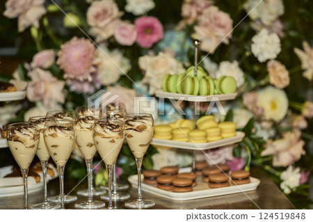 Candy bar. wedding cake decorated by flowers standing of table with desserts and cupcakes. Wedding. Reception Tartlets 124519848