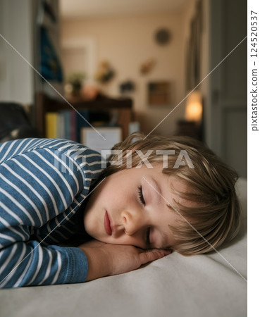 Side view of European child sleeping peacefully in bed with blurred room in background Side view of European child sleeping peacefully in bed with blurred room in background 124520537