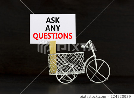 Ask any questions symbol. Concept words Ask any questions on beautiful white paper on clothespin. Beautiful black background. Miniature white bicycle. Business ask any questions concept. Copy space. Ask any questions symbol. Concept words Ask any questions on beautiful white paper on clothespin. Beautiful black background. Miniature white bicycle. Business ask any questions concept. Copy space. 124520929
