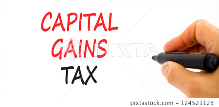 Capital gains tax symbol. Concept words Capital gains tax on beautiful white paper. Beautiful white background. Businessman hand with pen. Business and capital gains tax concept. Copy space. Capital gains tax symbol. Concept words Capital gains tax on beautiful white paper. Beautiful white background. Businessman hand with pen. Business and capital gains tax concept. Copy space. 124521123