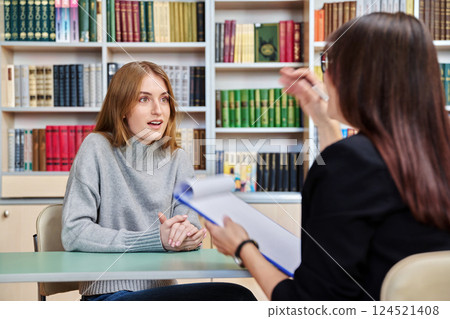 Young teenage girl student meeting with female college psychologist counselor 124521408