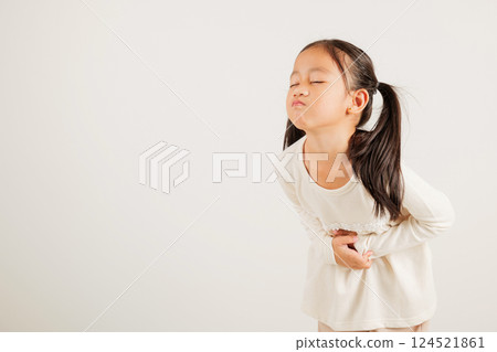 Portrait of Asian young kid girl has stomachache, kindergarten child abdominal pain suffering from stomach ache, studio shot isolated on white background, food poisoning, Health and medical gastritis 124521861