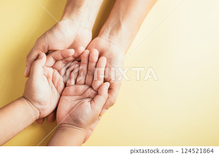 Close-up top view of family hands stacked on an isolated background in a studio shot. Parents and kids hold an empty space portraying support and love for Family and Parents Day. Close-up top view of family hands stacked on an isolated background in a studio shot. Parents and kids hold an empty space portraying support and love for Family and Parents Day. 124521864