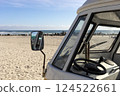 Window With Mirror Of Orange Camper Van Parked In The Seashore, Yellow Sand And Water, Ocean Line On Background, Travel Destination, Summer And Vacation. Horizontal. 124522661
