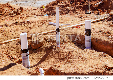 PVC pipes are positioned in sandy ground as part of ongoing construction work for wastewater 124522938