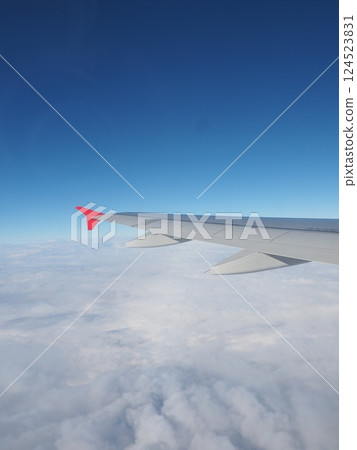 Blue sky and sea of clouds seen from an airplane 124523831