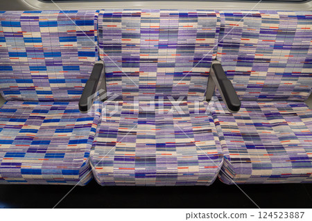 patterned purple seats inside the Elizabeth Line train showcases their geometric textile design. The seating is clean, structured, and features individual armrests for passenger comfort. 124523887