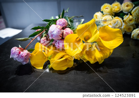Colorful flowers in vases and bouquets are arranged neatly inside a florist shop. The natural light and variety of blooms create a fresh, elegant atmosphere. Colorful flowers in vases and bouquets are arranged neatly inside a florist shop. The natural light and variety of blooms create a fresh, elegant atmosphere. 124523891