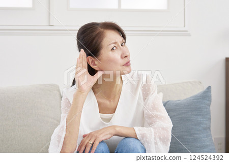Hearing-impaired senior woman in the living room 124524392
