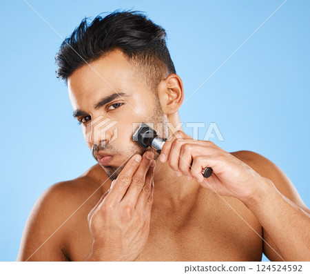 Man, beauty and shaving for facial grooming in skincare for fresh clean hygiene against a blue studio background. Male shave beard with razor in cosmetics, face and care treatment for healthy skin 124524592