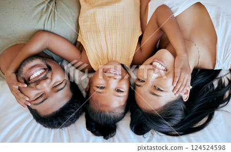 Family, portrait and relax in bed with love, smile and happy together with mother, father or girl in home. Above view of man, woman and child relaxing in a bedroom bonding, care and happiness in home 124524598