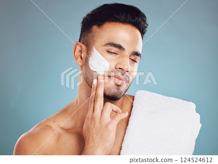 Face, skincare cream and man facial morning routine for beauty care. Young Indian person, hydrate skin treatment and grooming wellness or healthy dermatology bodycare in blue background studio 124524612