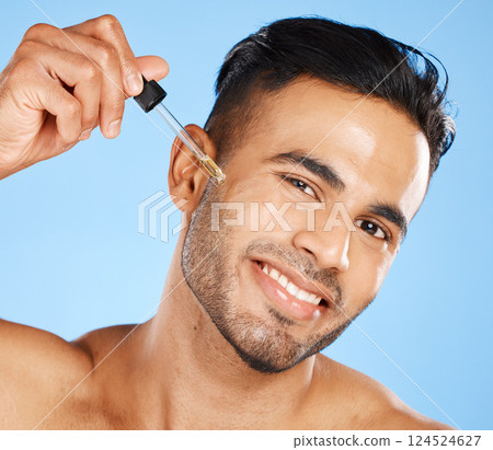 Man face, skin serum or beard oil of facial hair growth beauty product on blue studio background. Portrait of a happy young arab guy model, liquid dermatology and hyaluronic acid for body cosmetics Man face, skin serum or beard oil of facial hair growth beauty product on blue studio background. Portrait of a happy young arab guy model, liquid dermatology and hyaluronic acid for body cosmetics 124524627