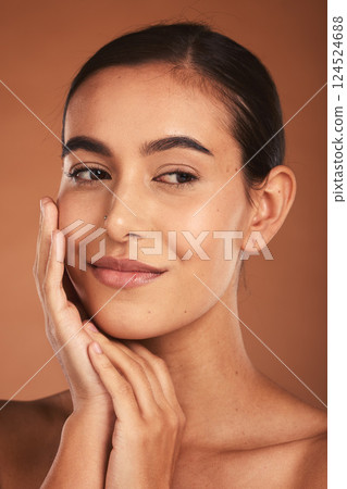 Skincare, beauty and face of Latina woman with smile, healthy and natural skin. Makeup, cosmetics and girl pose with hands for skincare products, spa and wellness isolated on brown background studio 124524688