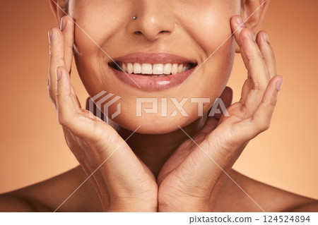 Hands, mouth and beauty with a model woman in studio on a beige background to promote wellness with a smile. Cosmetics, skincare and happy with a female posing to promote natural treatment or product 124524894