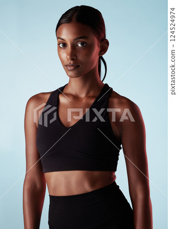 Fitness, health and sports portrait of woman isolated on a blue studio background. Vision, motivation and athletic female from India with goals for wellness, exercise or serious training workout. Fitness, health and sports portrait of woman isolated on a blue studio background. Vision, motivation and athletic female from India with goals for wellness, exercise or serious training workout. 124524974