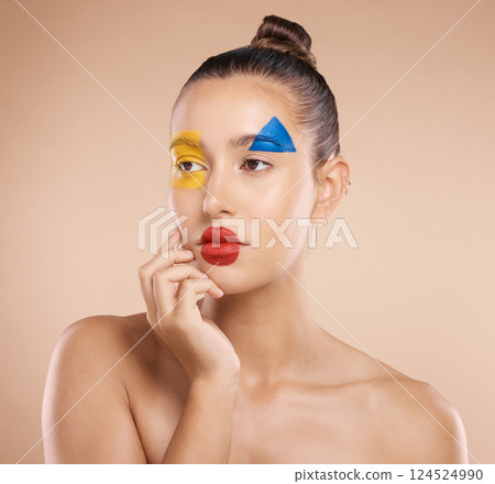 Beauty, art and portrait of woman paint on face, creative makeup and serious self expression. Skincare, creativity and hand touching cheek with artistic color shape cosmetics on young beautiful girl. 124524990