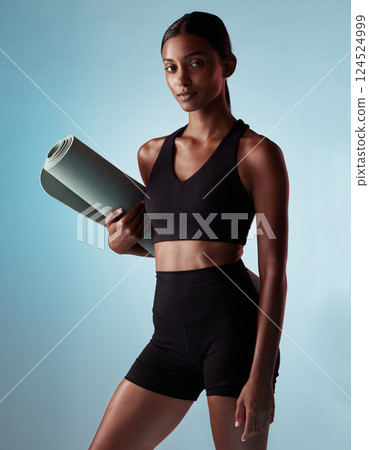 Woman, yoga mat or fitness on blue background in studio for relax workout, training or pilates exercise for mental health or wellness. Portrait, model or yogi with calm, zen or holistic peace mindset Woman, yoga mat or fitness on blue background in studio for relax workout, training or pilates exercise for mental health or wellness. Portrait, model or yogi with calm, zen or holistic peace mindset 124524999