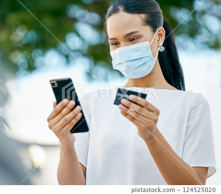 Covid, phone and woman in face mask with a credit card for a payment or to send cash on a digital application. Coronavirus, finance and healthy girl customer busy online shopping and money transfer 124525020