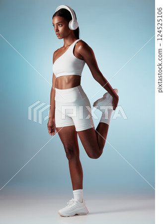 Fitness, music and stretching with woman and headphones for running, training and workout in blue background studio. Energy, freedom and health with girl runner streaming for sports, podcast or audio Fitness, music and stretching with woman and headphones for running, training and workout in blue background studio. Energy, freedom and health with girl runner streaming for sports, podcast or audio 124525106
