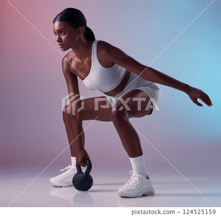 Fitness, exercise and woman with a kettlebell in studio strength training and burning calories in a full body exercise. Energy, workout and healthy girl swings a heavy weight for strong arms and legs Fitness, exercise and woman with a kettlebell in studio strength training and burning calories in a full body exercise. Energy, workout and healthy girl swings a heavy weight for strong arms and legs 124525159