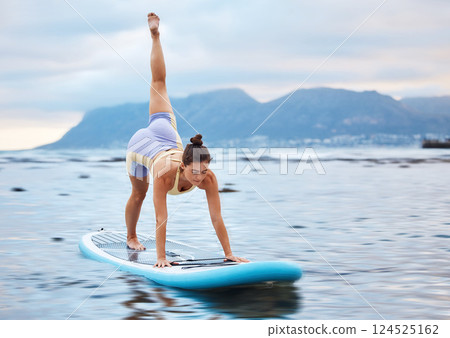 Surfer, flexible and woman on surfboard at a beach training, workout and full body yoga exercise on water in nature. Ocean, surfing and sports girl in a downward dog pose with balance and fitness Surfer, flexible and woman on surfboard at a beach training, workout and full body yoga exercise on water in nature. Ocean, surfing and sports girl in a downward dog pose with balance and fitness 124525162