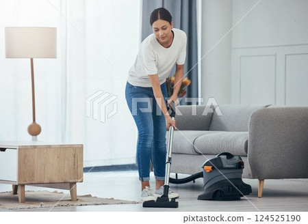 Woman, vacuum machine and cleaning the floor in the living room in home. Happy latino cleaner doing housework, housekeeper or job in a clean lounge, hotel room or house while alone spring cleaning 124525190
