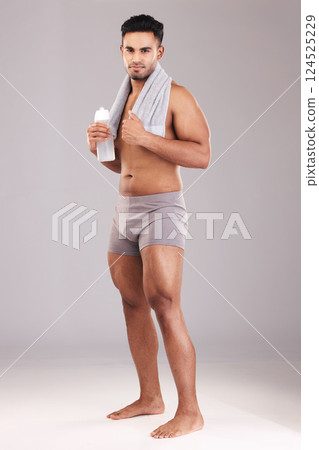Portrait, water bottle and man with towel isolated on gray studio background. Fitness, wellness and healthy athletic male from India ready for hydration after training, exercise or workout mock up. Portrait, water bottle and man with towel isolated on gray studio background. Fitness, wellness and healthy athletic male from India ready for hydration after training, exercise or workout mock up. 124525229