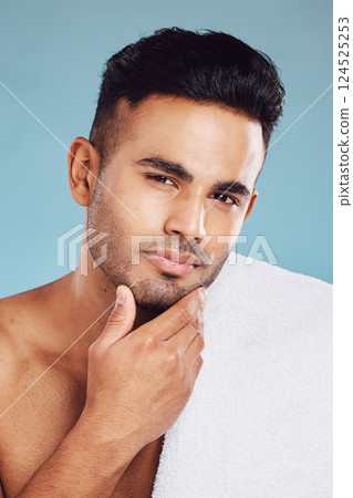 Hand, face and beauty with a man model posing in studio on a blue background for grooming or skincare. Portrait, luxury and wellness with a male indoors to promote a natural product or skin treatment Hand, face and beauty with a man model posing in studio on a blue background for grooming or skincare. Portrait, luxury and wellness with a male indoors to promote a natural product or skin treatment 124525253