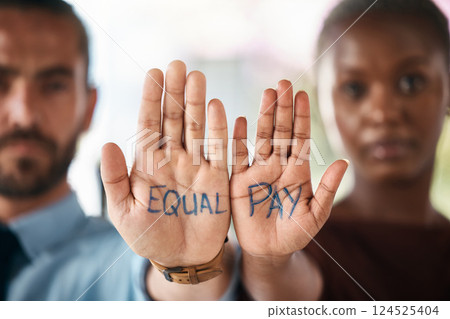 Hands, equality and empowerment with a business man and woman showing an equal pay notice in their palms. Team, community and collaboration with male and female colleagues standing together in unity 124525404
