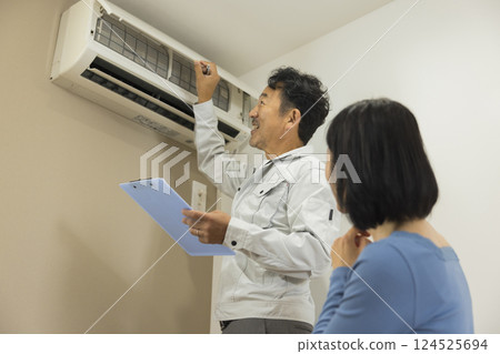 Workers inspecting air conditioners 124525694