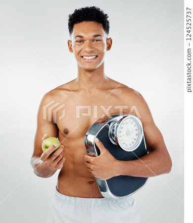 Apple, man and scale for health, fitness and diet in studio against white background mockup for weight loss. Fruit, training and wellness model with black man happy, smile and relax with nutrition Apple, man and scale for health, fitness and diet in studio against white background mockup for weight loss. Fruit, training and wellness model with black man happy, smile and relax with nutrition 124525737