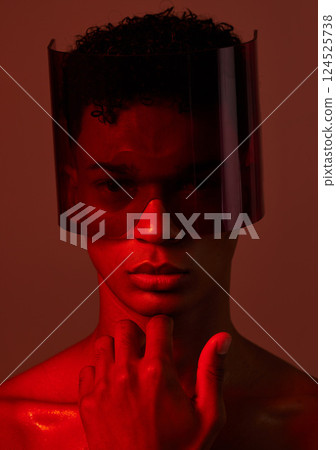 Red future night, black man portrait and futuristic punk glasses on face against dark background in studio. Cyber model man, plastic visor mask and cyberpunk aesthetic with creative wall backdrop Red future night, black man portrait and futuristic punk glasses on face against dark background in studio. Cyber model man, plastic visor mask and cyberpunk aesthetic with creative wall backdrop 124525738
