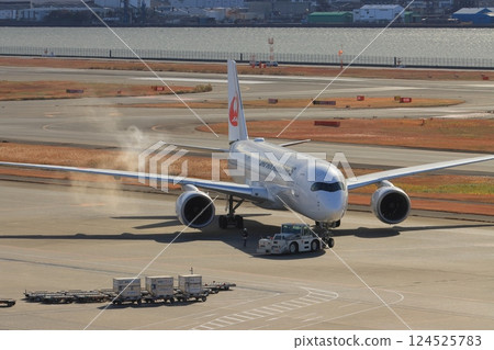 JAL plane starting engines JAL plane being pushed back 124525783