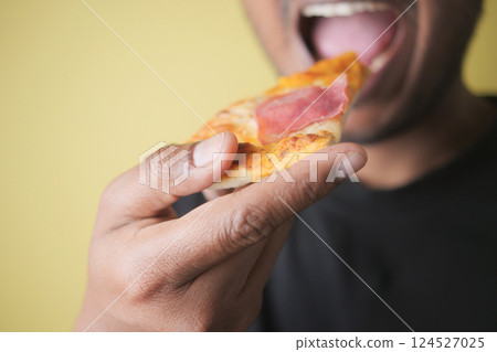 Enjoying a slice of pizza in a casual indoor setting Enjoying a slice of pizza in a casual indoor setting 124527025