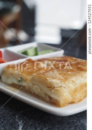 Delicious turkish borek served with fresh vegetables at a cafe 124527031