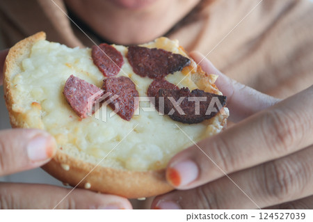 Delicious close-up of a savory bun topped with sausage slices 124527039