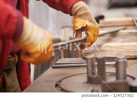 Crafting metal rods in a workshop during daylight hours Crafting metal rods in a workshop during daylight hours 124527302