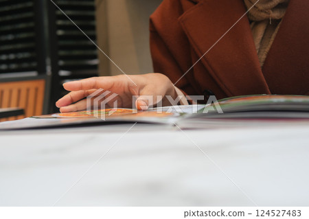 Hand flipping through a menu at a cozy cafe in autumn 124527483