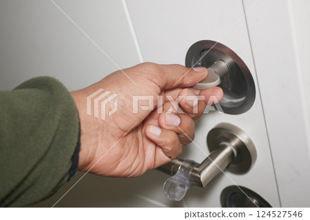 Hand inserting key into door lock in a residential setting 124527546
