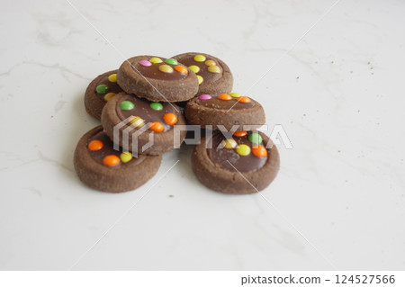 Delicious chocolate cookies topped with colorful candy discs 124527566