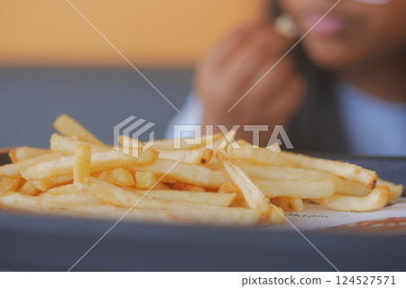 child hand pick Crispy golden fries served in a casual dining setting child hand pick Crispy golden fries served in a casual dining setting 124527571
