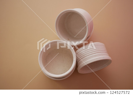 Small white containers stacked on a light background for storage 124527572