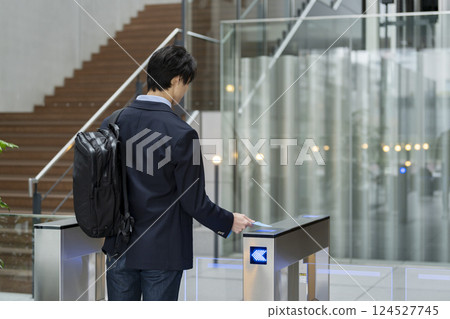 商人穿過辦公大樓的安全門，後視 124527745