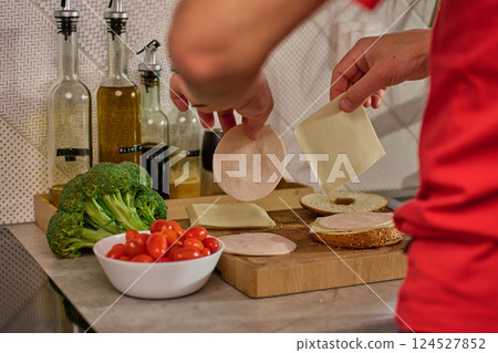 Preparing bagel sandwich with cheese and ham Preparing bagel sandwich with cheese and ham 124527852