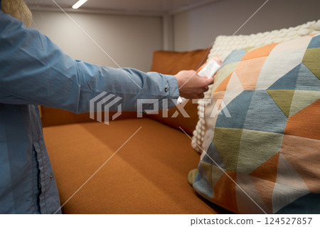Woman choosing sofa cushion in furniture store 124527857