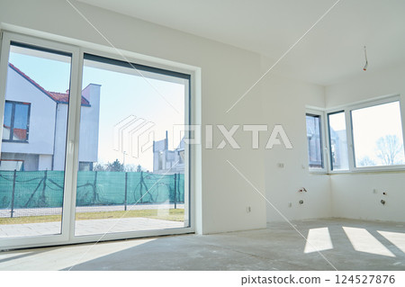 Interior of new home with large panoramic windows and bare floor 124527876